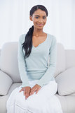 Attractive woman sitting on cosy sofa
