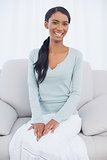 Smiling attractive woman sitting on cosy sofa