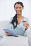 Smiling attractive woman using her tablet pc to buy online