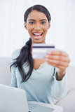Smiling pretty woman using her laptop to buy online