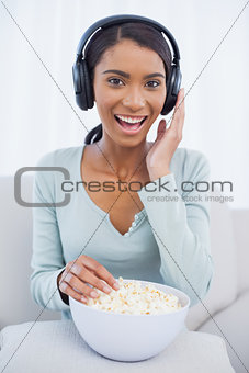 Attractive woman eating popcorn while listening to music