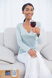 Smiling attractive woman holding glass of red wine