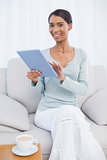 Smiling attractive woman using her tablet computer