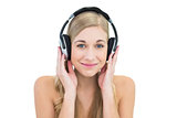 Delighted young blonde woman listening to music