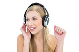 Serious young blonde woman listening to music