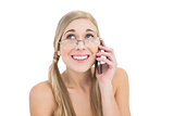 Embarrassed young blonde woman calling someone with her mobile phone