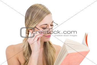 Concentrated young blonde woman reading a book