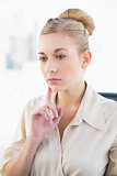 Pensive young blonde businesswoman thinking