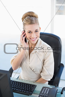 Cheerful young blonde businesswoman calling with her mobile phone