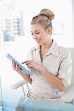 Attentive young blonde businesswoman using her tablet pc