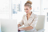 Concentrated young blonde businesswoman using a laptop