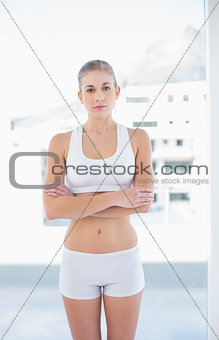 Charming young blonde model posing with crossed arms