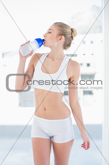 Attractive young blonde model drinking water in a bottle
