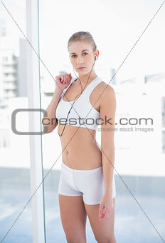 Stern young blonde model listening to music