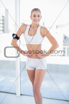 Happy young blonde model listening to music