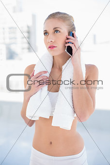 Thoughtful young blonde model calling with her mobile phone