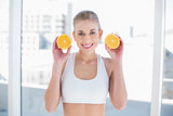 Attractive young blonde model holding two halves of an orange
