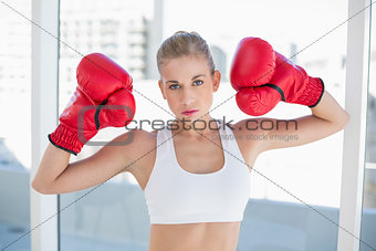 Dynamic young blonde model wearing boxing gloves