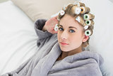 Beautiful relaxed blonde woman in hair curlers looking at camera