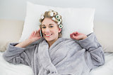 Cute relaxed blonde woman in hair curlers calling with her mobile phone