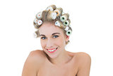 Charming relaxed blonde model in hair curlers looking at camera