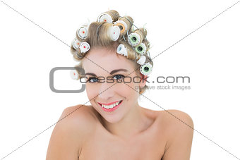 Charming relaxed blonde model in hair curlers looking at camera