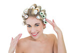 Content blonde model adjusting her hair curlers