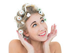 Joyful blonde model adjusting her hair curlers