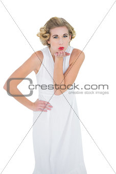 Attractive fashion blonde model blowing a kiss to the camera