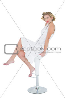 Attractive fashion blonde model posing sitting on bar chair