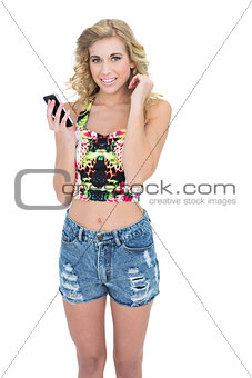 Cheerful retro blonde model using a mobile phone