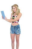 Charming retro blonde model looking at a tablet pc