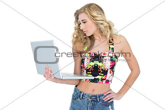 Thoughtful retro blonde model using a laptop
