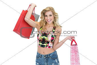 Joyful retro blonde model carrying shopping bags