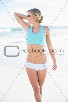 Cheerful blonde model in sportswear posing looking away