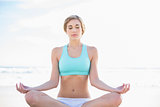 Peaceful blonde woman in sportswear practicing yoga