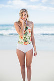 Stern blonde model in swimsuit posing looking at camera
