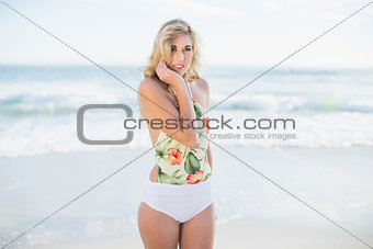 Pensive blonde model in swimsuit posing looking at camera
