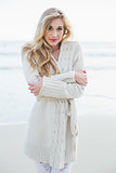 Attractive blonde woman in wool cardigan looking at camera