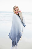 Charming blonde woman covering herself in a blanket