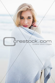 Peaceful blonde woman covering herself in a blanket