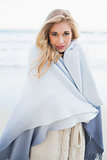 Fashion blonde woman covering herself in a blanket