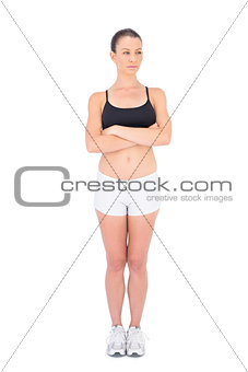 Unsmiling woman in sportswear crossing arms looking away