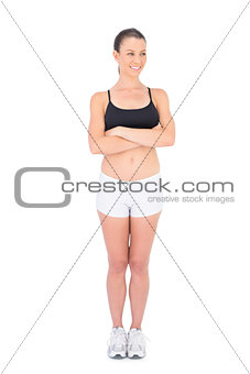 Smiling woman in sportswear crossing arms