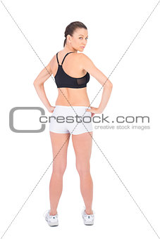 Serious woman in sportswear standing back to camera