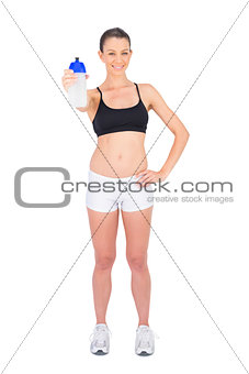 Cheerful woman in sportswear holding flask