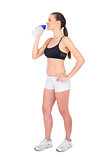 Peaceful fit woman in sportswear drinking water