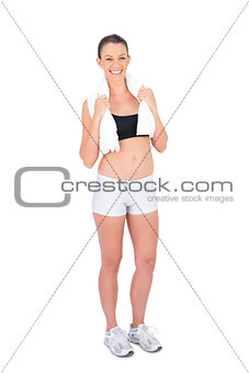Smiling fit model in sportswear holding sport towel
