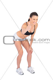 Cheerful fit model in sportswear giving thumb up to camera