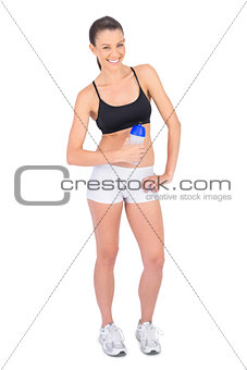 Happy fit model in sportswear holding flask